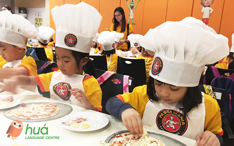 Children making pizza during a Chinese holiday programme.
