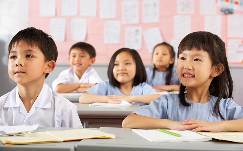 Children in classroom listening attentively.